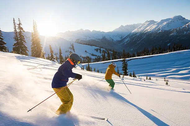 Couple skiing on a sunny powder day